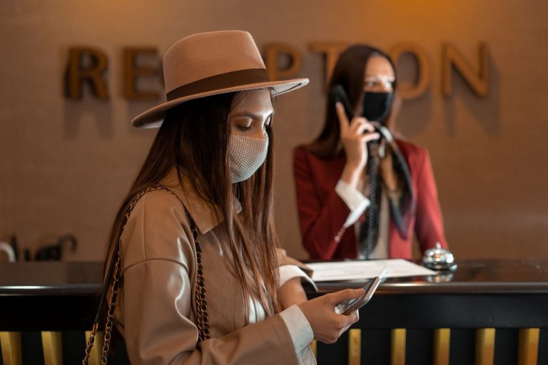 Viajante usando o celular na recepção de um hotel.